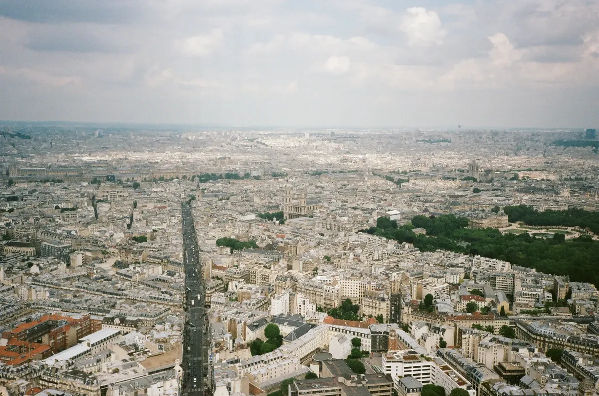 Aerial photograph capturing the expansive view of Paris cityscape including boulevards and urban architecture.