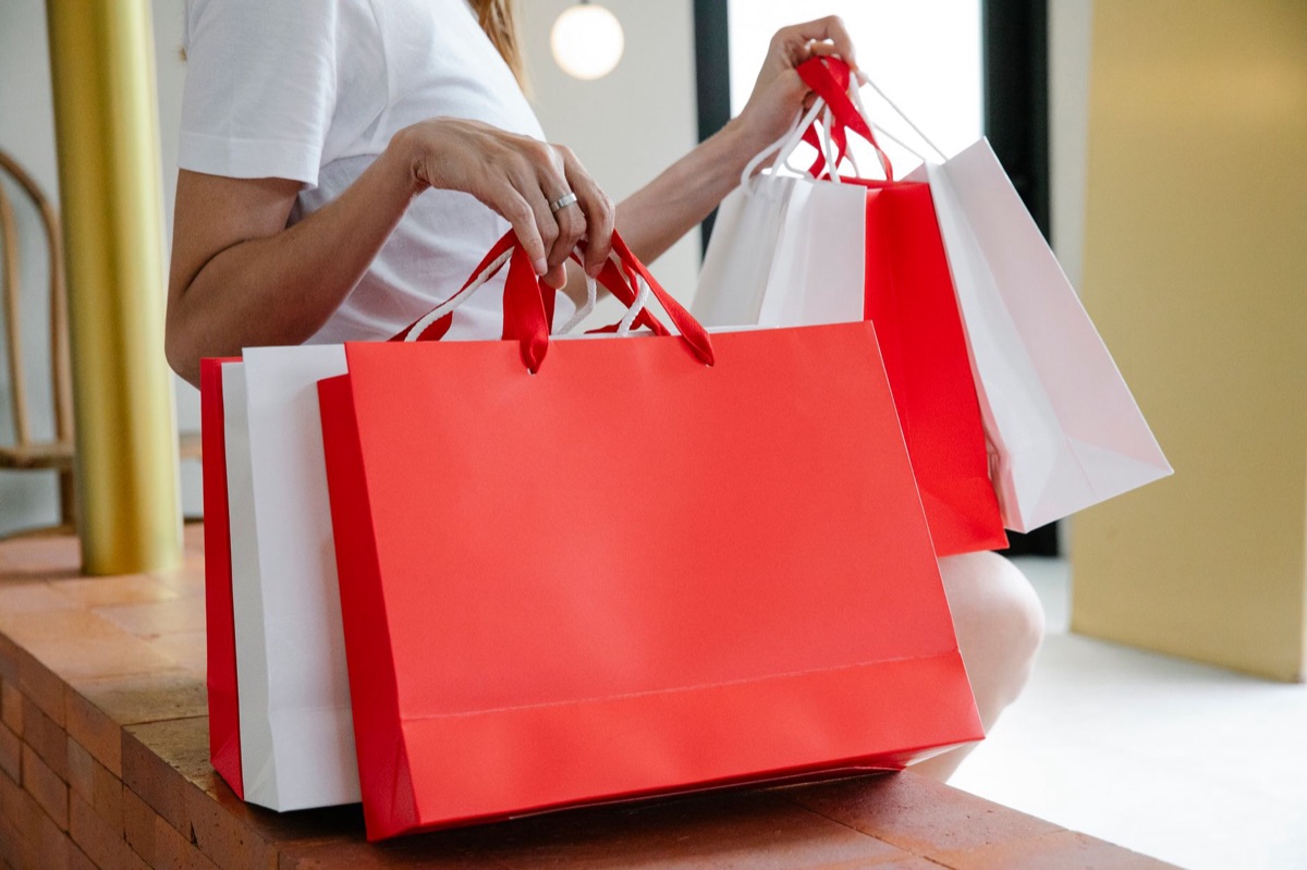Parisian shopper at luxury department store with a handbag and a shopping bag