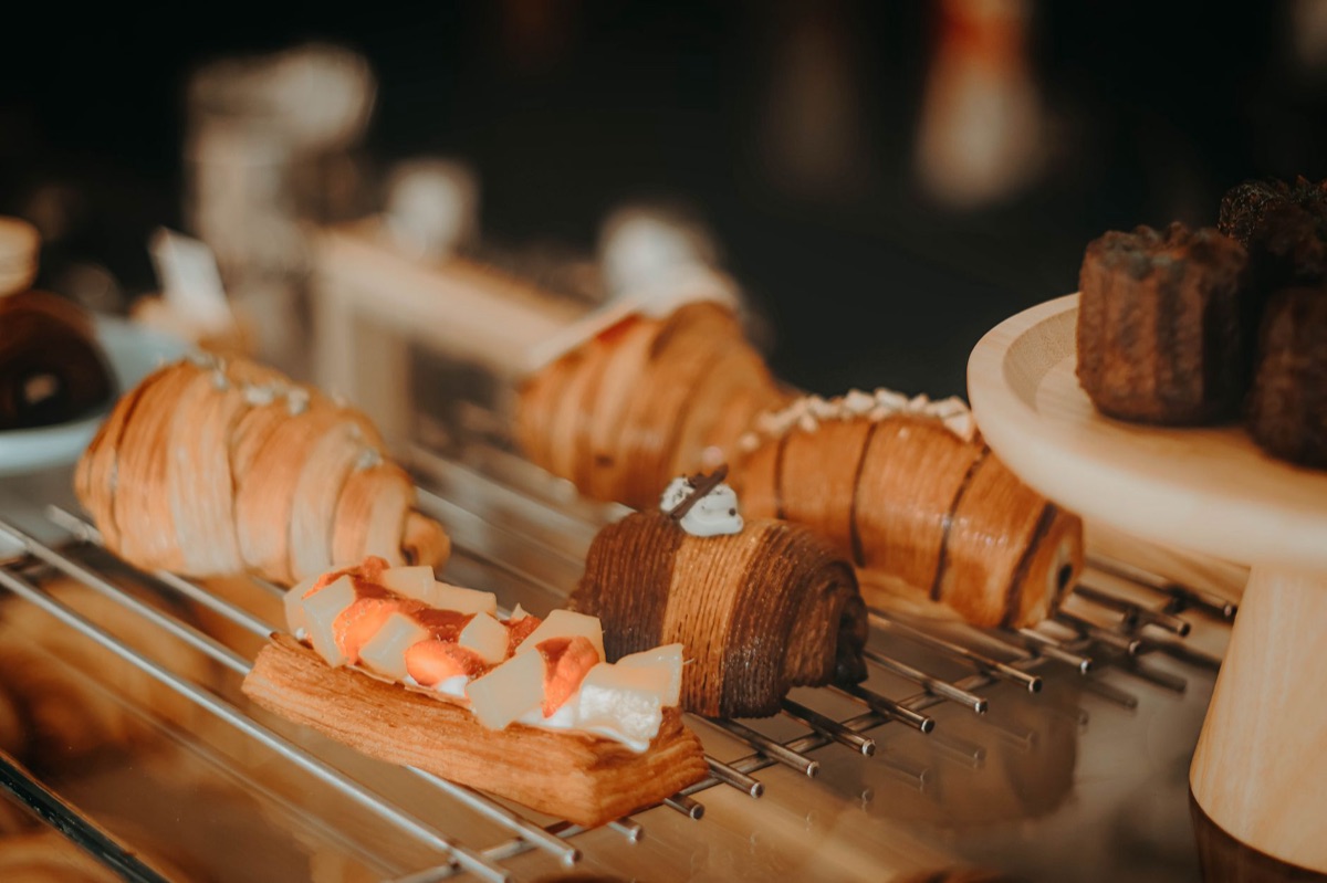 Una pasticceria a Parigi con un croissant e il segno 'i luv paris'