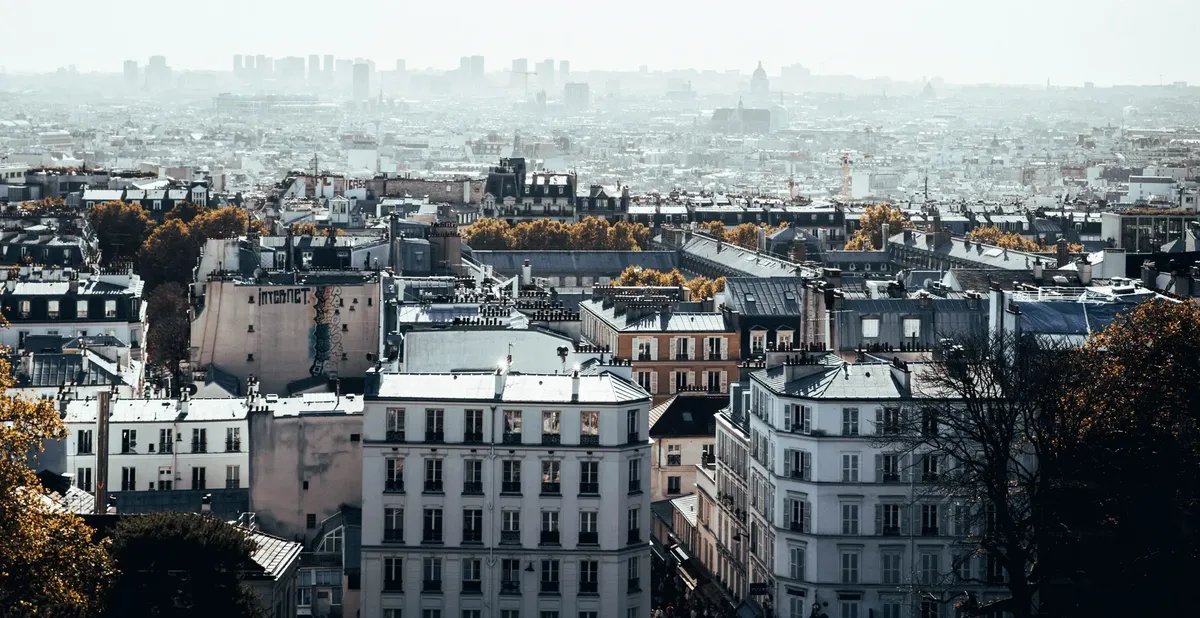 Aerial view of Paris with classic architecture under a hazy sky, capturing the city's charm.